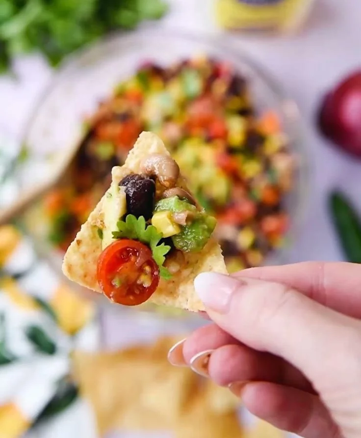 Colorful bowl of cowboy caviar featuring black-eyed peas and fresh vegetables.