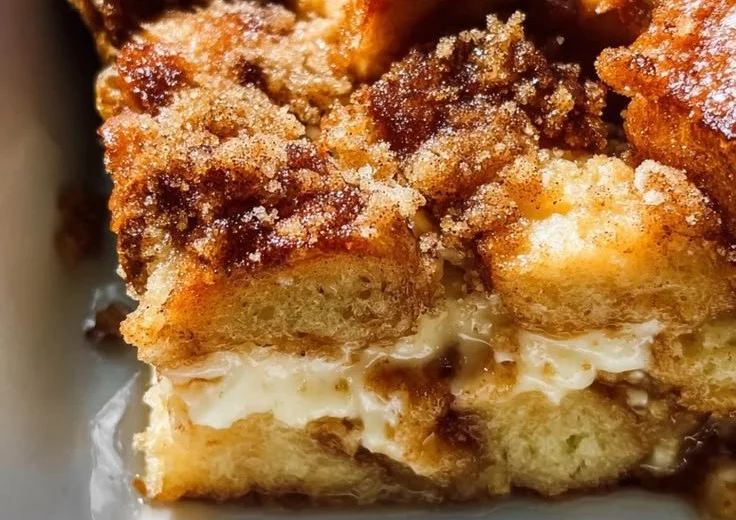 Creamy baked cream cheese French toast casserole served on a plate with berries.